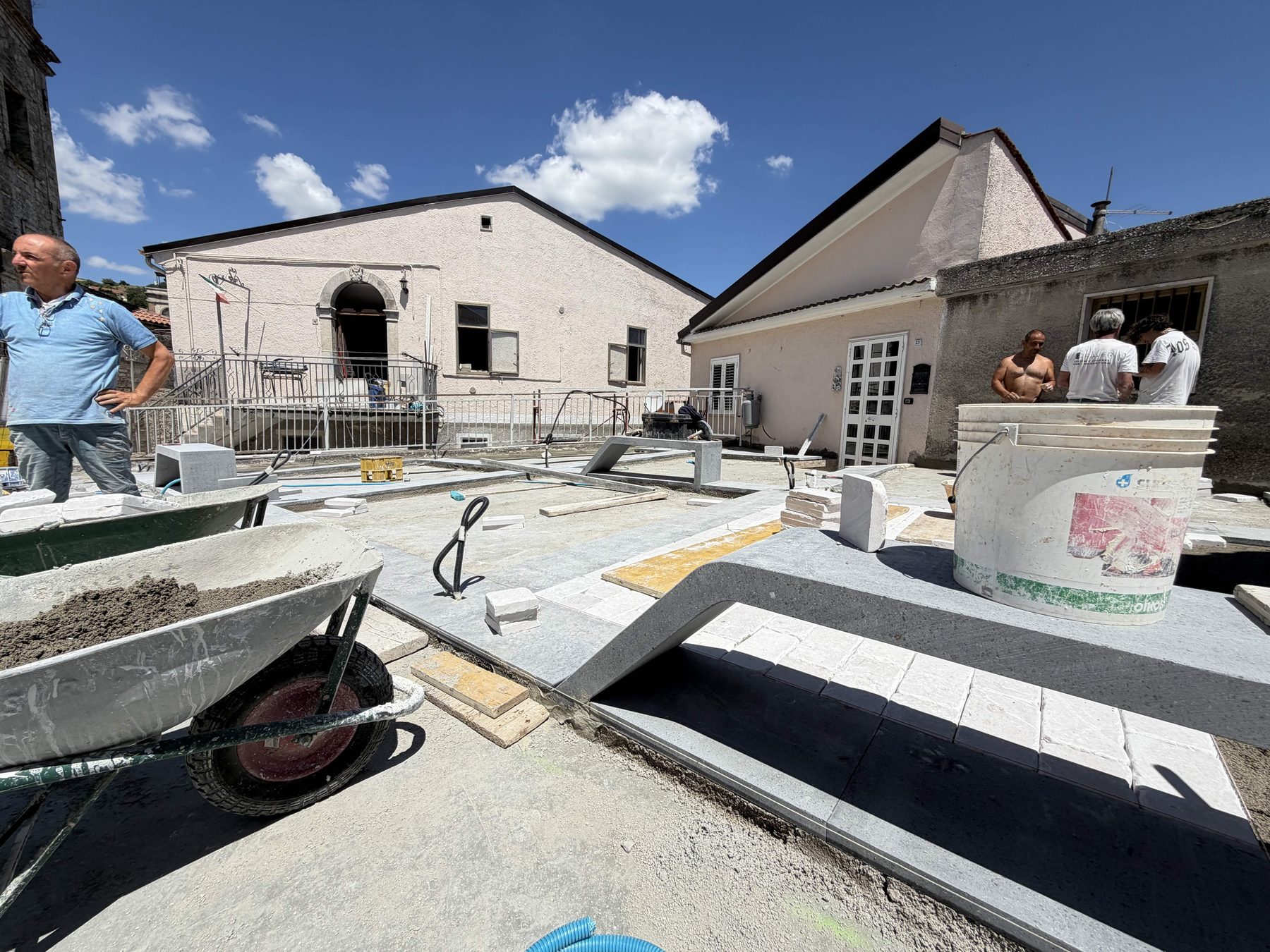 operai al lavoro con i listoni di basalto grigio, cantiere piazza di faeto